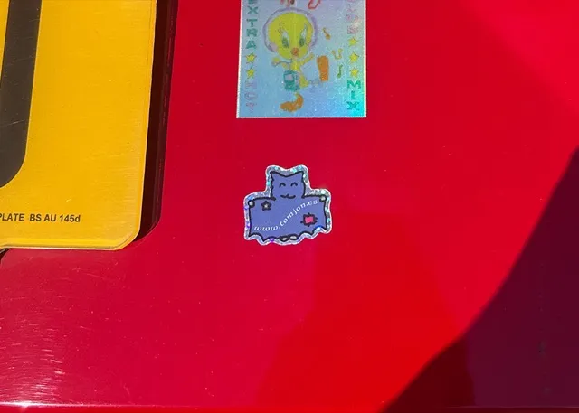 glittery bat sticker on a red car.